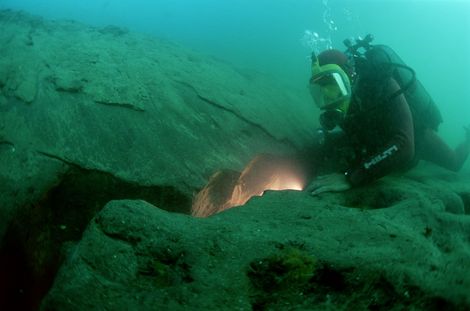 在坎诺普斯东部一座气势恢宏的纪念碑附近（可能是塞拉皮斯神庙），潜水员正在检查一条沟渠的淤泥层中的断层状构造。